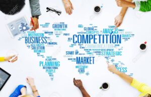 Concepto de competencia. Mapa del mundo donde aparecen palabras como competencia en inglés. El mapa parece una mesa y alrededor aparecen brazos de personas como si estuvieran hablando.